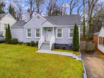 Charming home with a light grey brick facade, manicured lawn, and inviting front entrance steps at 1318 Beecher St, Atlanta, GA 30310