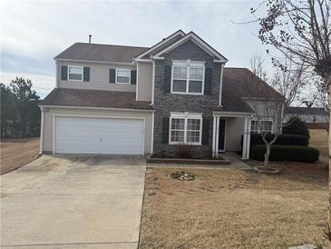 Charming two-story home featuring stone accents and a well-maintained front yard at 1631 Royal Ives Dr, Lawrenceville, GA 30045