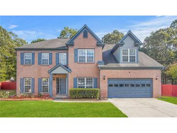 Charming two-story brick home with blue shutters, attached garage, and well-manicured lawn at 1021 Adah Ln, Lawrenceville, GA 30043