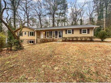 Charming ranch-style home with a cozy front porch and mature trees, providing curb appeal at 4726 Alpine Sw Dr, Lilburn, GA 30047