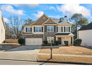 Charming two-story home with a stone and siding facade, well-manicured lawn, and a two-car garage at 3240 Arbor Oaks Dr, Snellville, GA 30039