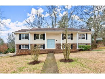 Charming two-story home with a light blue door, black shutters, and a well-manicured front yard at 3284 Devaughn Ne Dr, Marietta, GA 30066
