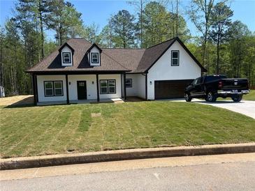 Charming new construction home with a manicured lawn, modern white siding and black trim at 200 Brookwood Xing, Douglasville, GA 30134