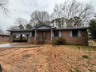 Charming brick home with an attached carport and welcoming front entrance with a small front yard at 3450 Estes Dr, Atlanta, GA 30349