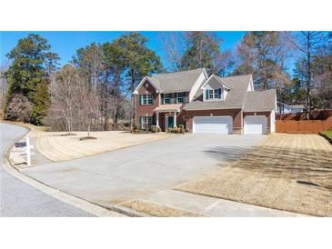Charming two-story brick home with a well-manicured front yard and a three-car garage at 1105 Fountain Head Ln, Lawrenceville, GA 30043