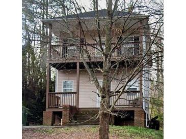 Two-story home featuring double balconies, a neutral exterior, and natural surroundings at 1466 Andrews Nw St, Atlanta, GA 30314