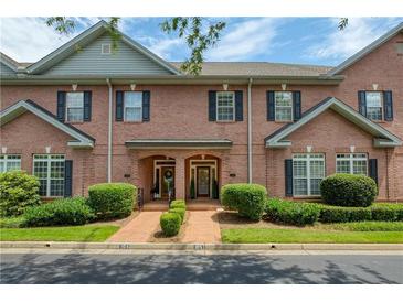 Charming brick townhome exterior featuring well-manicured landscaping and inviting front entrances at 1950 Buford Dam Rd # 105, Cumming, GA 30041