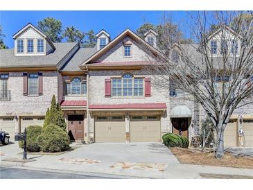 Charming brick townhome with two-car garage and manicured landscaping at 6288 Clapham Ln, Johns Creek, GA 30097