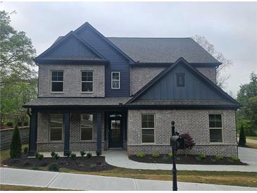 Charming two-story brick home with blue accents and a well-manicured lawn at 110 Jackson St, Buford, GA 30518