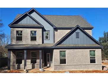 Two-story brick home boasting large windows, gray siding accents, and a covered front porch at 110 Jackson St, Buford, GA 30518