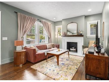 Cozy living room with a decorative fireplace, plush sofa, and hardwood floors at 427 S Columbia Dr, Decatur, GA 30030