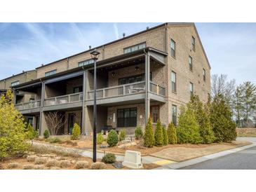 Beautiful brick townhome with covered front porches and professional landscaping at 6460 Cortland Walk, Alpharetta, GA 30005