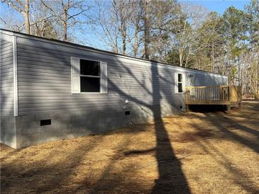 Exterior view of home with gray siding, white trim, and wood deck at 155 Emily Dr, Whitesburg, GA 30185