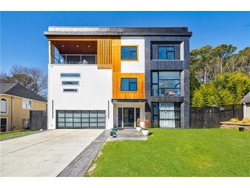 Modern home showcasing a three-story facade with mixed textures, large windows, and an attached garage at 1812 Hunters Gln, Marietta, GA 30062