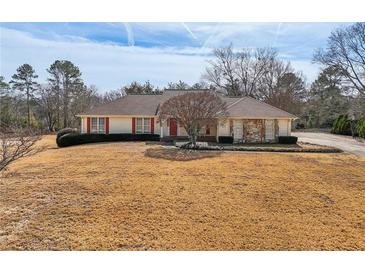 Ranch-style home with stone accents, a manicured lawn, and mature trees, offering curb appeal at 755 Rounsaville Rd, Roswell, GA 30076