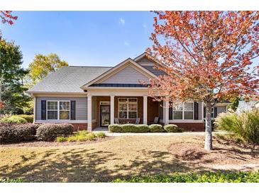 Charming single-story home featuring a covered front porch, well-maintained lawn, and mature trees at 1350 Bluestone Dr, Cumming, GA 30041