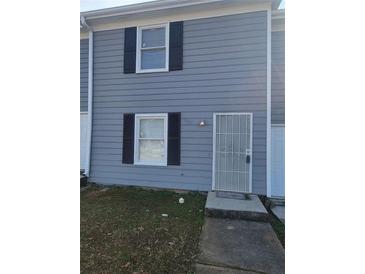 Charming townhome with gray siding, black shutters, and a secure metal door at 2627 Evans Mill Dr, Lithonia, GA 30058