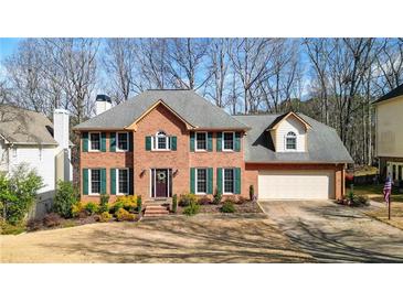 Charming two-story brick home with well-manicured lawn, green shutters, and a welcoming front door at 4314 Deep Springs Nw Ct, Kennesaw, GA 30144