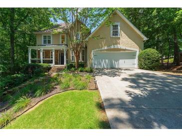 Charming home featuring a covered front porch, well-manicured lawn and an attached garage at 4010 Tamarack Nw Dr, Kennesaw, GA 30152