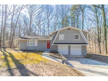Charming split-level home featuring a two-car garage and a distinctive red front door at 3585 Ale Cir, Atlanta, GA 30344