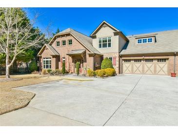 Charming brick home featuring a three car garage and a well-manicured front yard, offering classic suburban appeal at 2817 Middlecreek Way # 1703, Cumming, GA 30041
