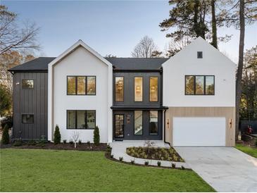 Modern home showcasing a well-manicured lawn, contrasting dark and white exterior, and a two-car garage at 198 Johnson Ferry Nw Rd, Atlanta, GA 30328