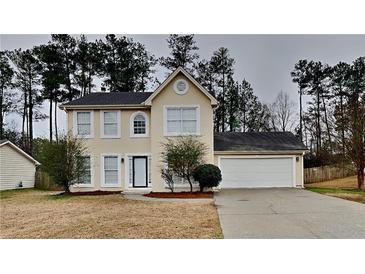 Two-story home with a well-manicured front yard and attached two car garage at 8541 Glendevon Ct, Riverdale, GA 30274
