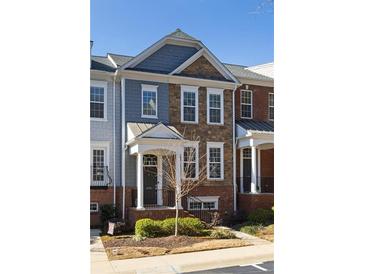 Charming townhouse with a mix of stone and blue siding, featuring a covered porch and well-maintained landscaping at 2316 Limehurst Ne Dr, Atlanta, GA 30319