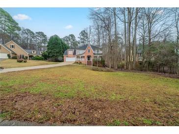 Charming two-story home with a brick facade, landscaped yard, and driveway at 4570 Thicket Trl, Snellville, GA 30039