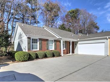 Charming home with a brick and siding exterior, complemented by a well-maintained lawn and an attached two-car garage at 2357 Barrett Cottage Pl, Marietta, GA 30066