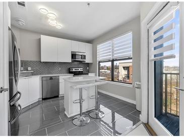 Modern kitchen features stainless steel appliances, island with seating, and sleek white cabinets at 898 Oak Sw St # 1306, Atlanta, GA 30310