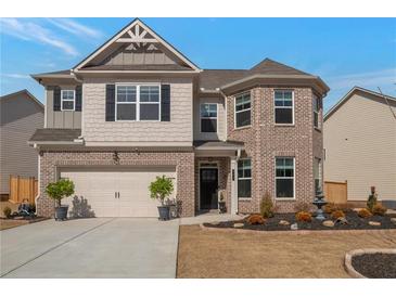 Beautiful two-story home featuring brick and beige siding, manicured landscaping, and a two-car garage at 531 Eagles Nest Cir, Auburn, GA 30011