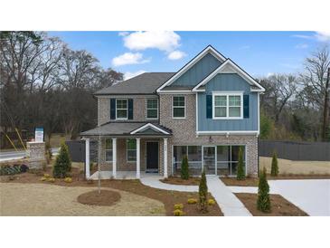 Charming two-story home boasts brick accents and a welcoming front porch with a beautifully landscaped yard at 590 River Garden Dr, Atlanta, GA 30354