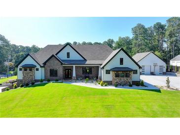 Stunning brick home with a well-manicured lawn, three car garage, and elegant details at 783 Blackberry Trl, Lawrenceville, GA 30043