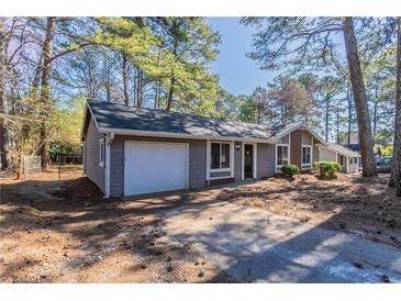 Charming single-story home featuring a one-car garage and traditional design at 9090 Dorsey Rd, Riverdale, GA 30274