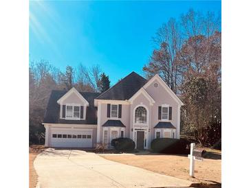 Charming two-story home with a manicured lawn and a two-car garage at 2030 Calmwater Ct, Suwanee, GA 30024