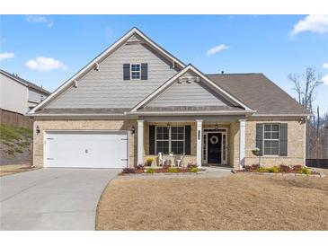 Charming single-story brick home with a well-manicured lawn and an inviting front porch at 7995 Brewton Creek Dr, Cumming, GA 30028