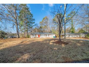 Charming one-story home featuring a well-maintained front lawn and a bright red front door at 1433 Dennis Dr, Decatur, GA 30032