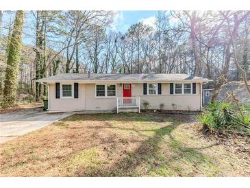 Charming one-story home with a red front door and a well-maintained lawn at 3192 Belfort Se Rd, Atlanta, GA 30354