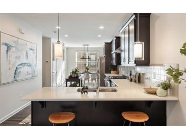 Modern kitchen features stainless steel appliances, a breakfast bar, and pendant lighting at 754 Aerial Way, Atlanta, GA 30312