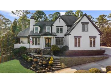 Charming two-story painted brick home featuring a landscaped yard and covered porch at 135 Newcastle Ct, Roswell, GA 30076