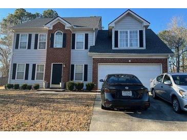 Charming two-story home featuring a brick facade and a well-maintained front yard at 232 Rockingham Dr, Loganville, GA 30052