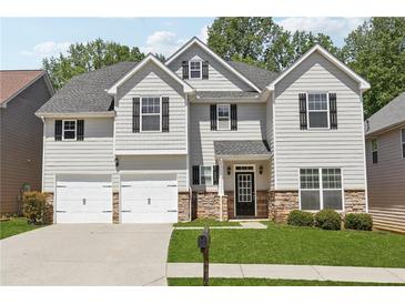 Charming two-story home featuring a manicured lawn, stone accents, and a two-car garage at 4416 Water Mill Dr, Buford, GA 30519