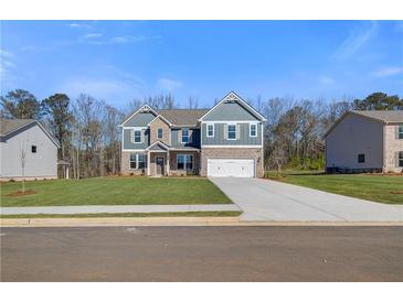 Charming two-story home featuring a brick and siding exterior, a well-manicured lawn, and a two-car garage at 120 Felicity Pike, Locust Grove, GA 30248