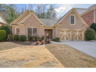 Charming brick home featuring a two-car garage and well-maintained front yard landscaping at 620 Willow Haven Way, Suwanee, GA 30024
