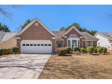 Charming brick home featuring a two-car garage, manicured shrubs, and a well-maintained front yard at 2794 Hillvale Cove Way, Lithonia, GA 30058