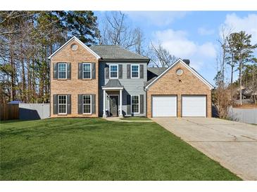 Charming two-story home with brick and siding, a well-manicured lawn, and an attached two-car garage at 3185 Perch Sw Dr, Marietta, GA 30008