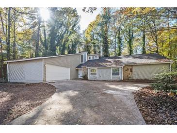 Charming single-Gathering home with a well-maintained lawn, mature trees, and a two-car garage at 5474 Post Road Pass, Stone Mountain, GA 30088