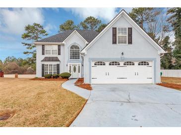 Charming two-story home features a two-car garage, manicured lawn, and classic architectural details at 5705 Mountain Cres, Stone Mountain, GA 30087