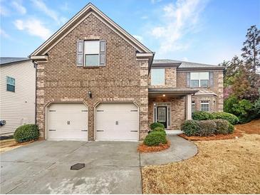 Charming brick home with a two-car garage and well-maintained landscaping at 2100 Trinity Mill Dr, Dacula, GA 30019